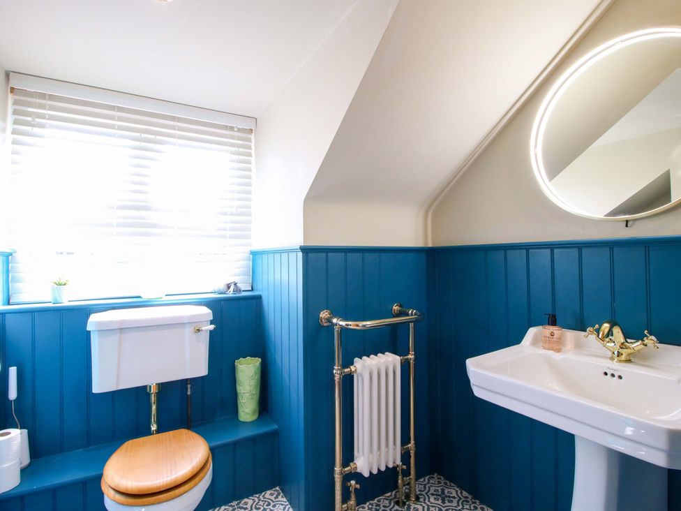 A bathroom with a toilet and sink at The Hideaway in Longden