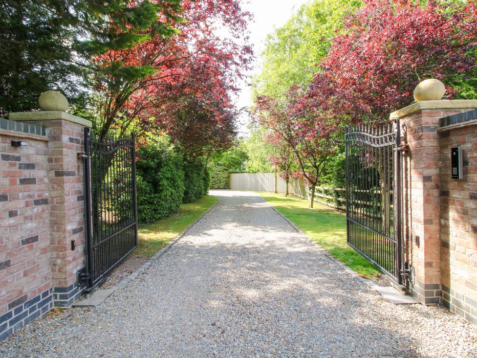 An outdoor driveway leading through a gated entrance at The Hideaway in Longden
