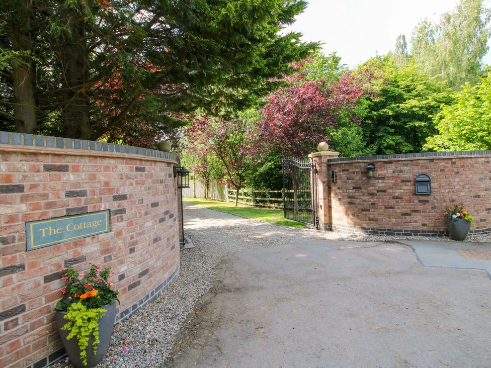 An entrance with a gate and flower pot at The Cottage in Longden