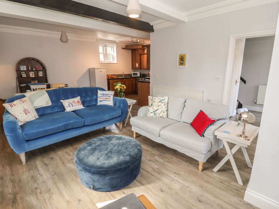 A living room with a blue sofa and coffee table at 6 The Mews in Felixstowe, Suffolk