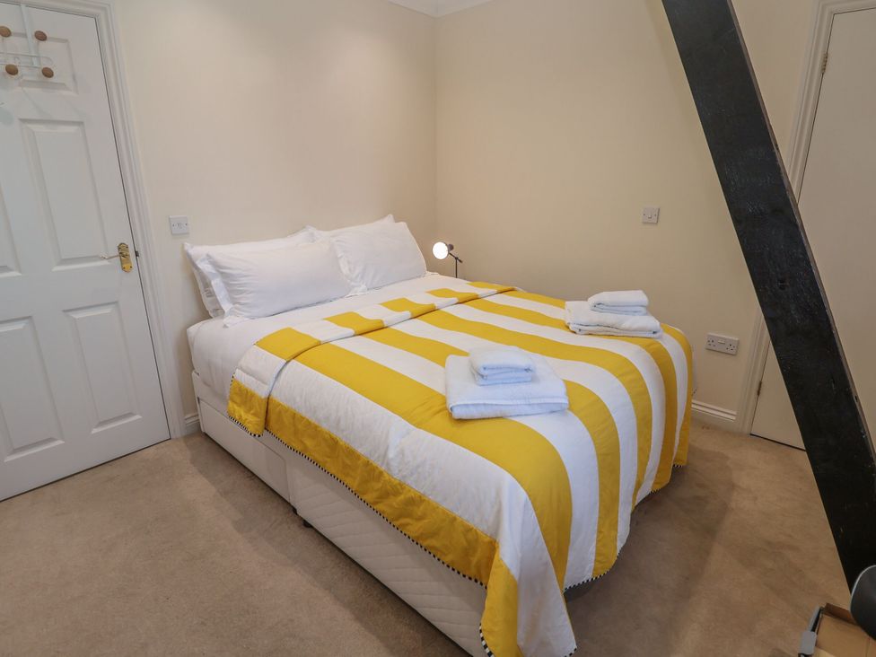 A bedroom with a bed and towels on top at 6 The Mews, Felixstowe, Suffolk