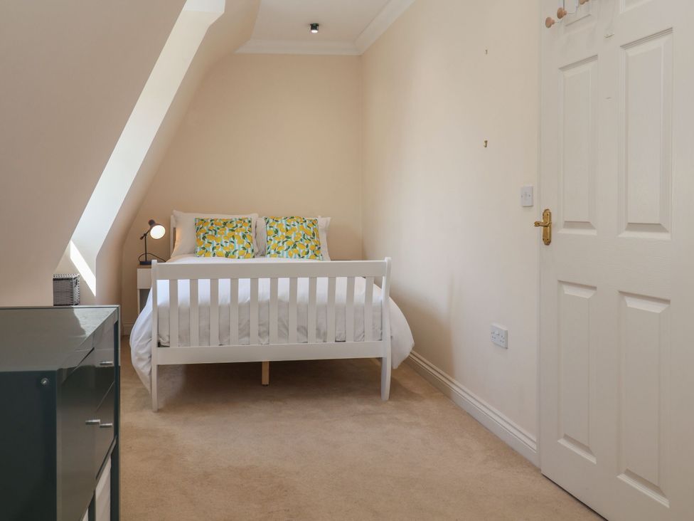 A bedroom with a bed and dresser at 6 The Mews, Felixstowe, Suffolk
