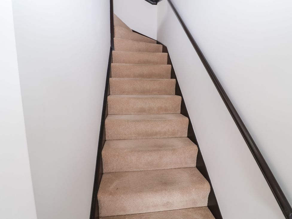 A staircase with carpeted steps and a handrail at Old Felixstowe, Bath Road