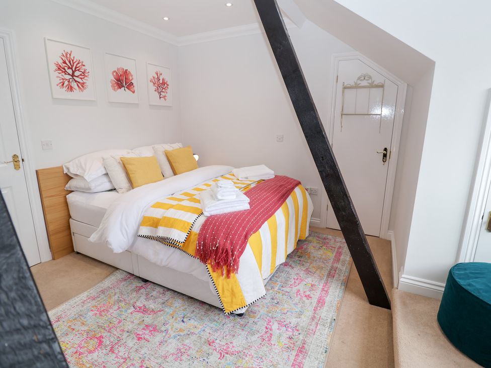A bedroom with a bed and wall art at Old Felixstowe, Bath Road, Felixstowe, Suffolk