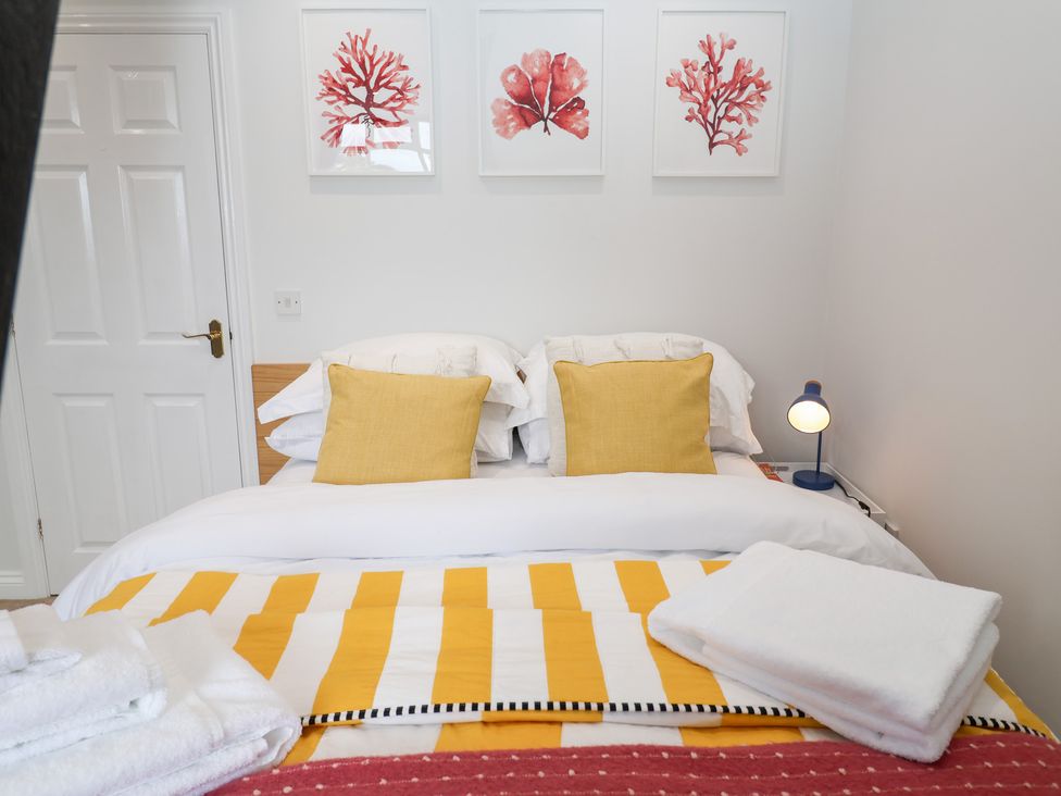 A bedroom with a bed and wall art at Old Felixstowe, Bath Road, Felixstowe, Suffolk