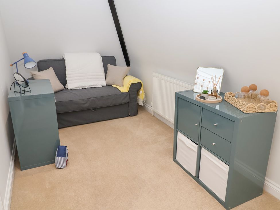 A snug area with a sofa and shelving unit at Old Felixstowe, Bath Road, Felixstowe, Suffolk