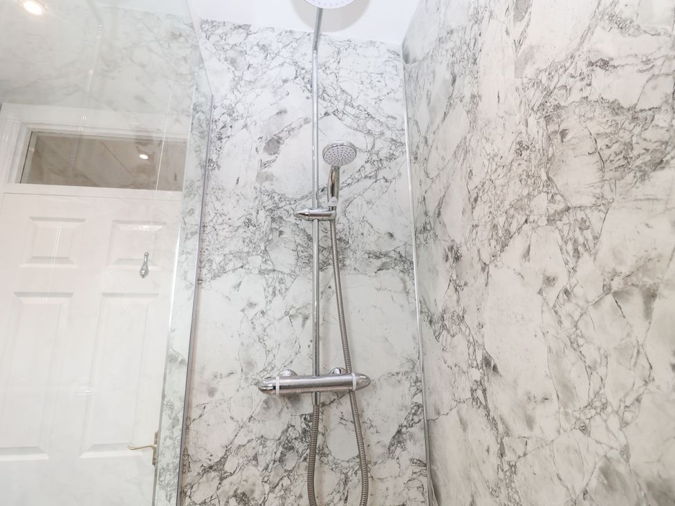 A shower with a marble wall and glass enclosure at Old Felixstowe, Bath Road, Felixstowe, Suffolk