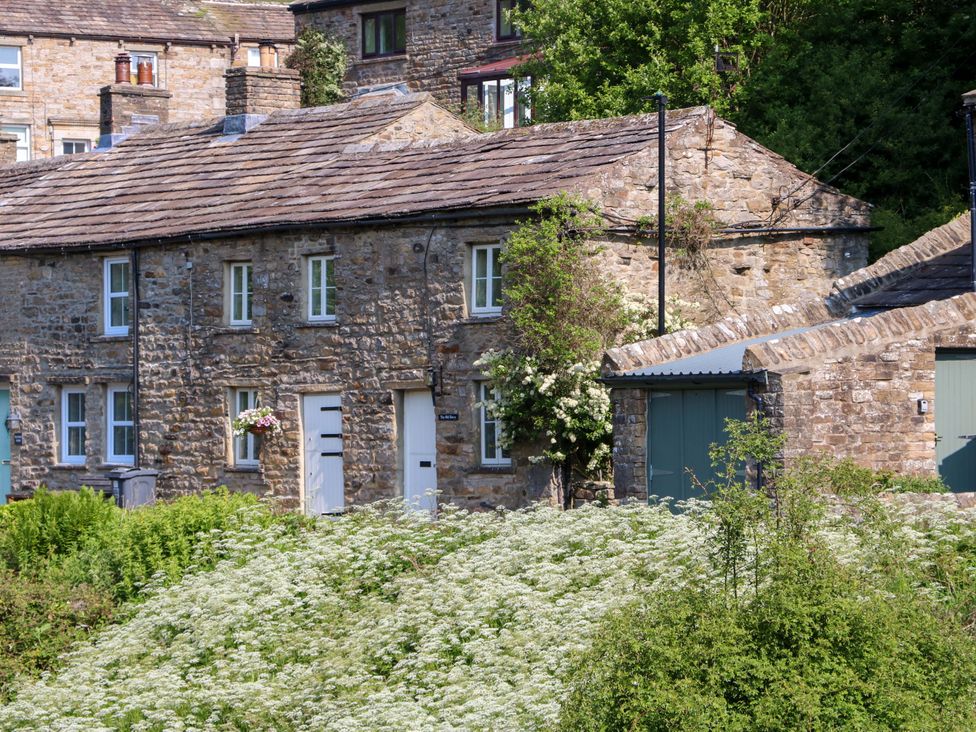 A stone house and garage with plants at The Old Dairy in Richmond
