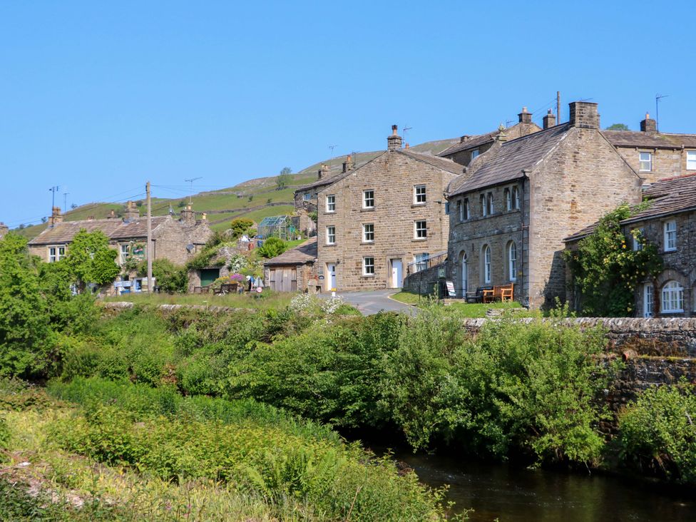 A view of stone buildings beside a river at The Old Dairy in Richmond