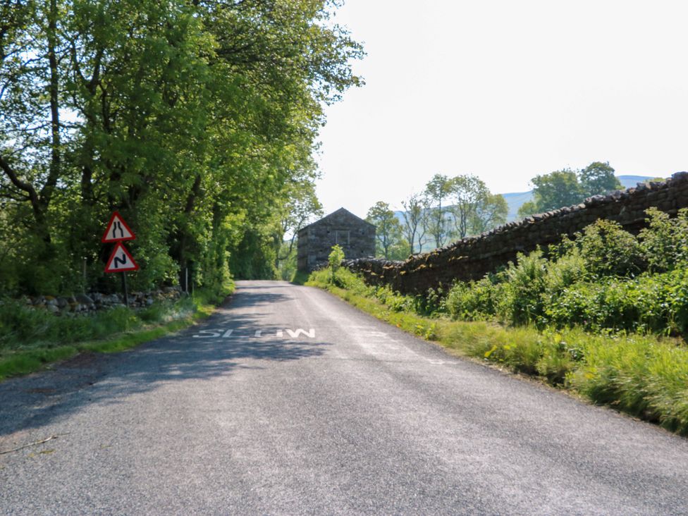 A road with a stone building and trees at The Old Dairy in Richmond