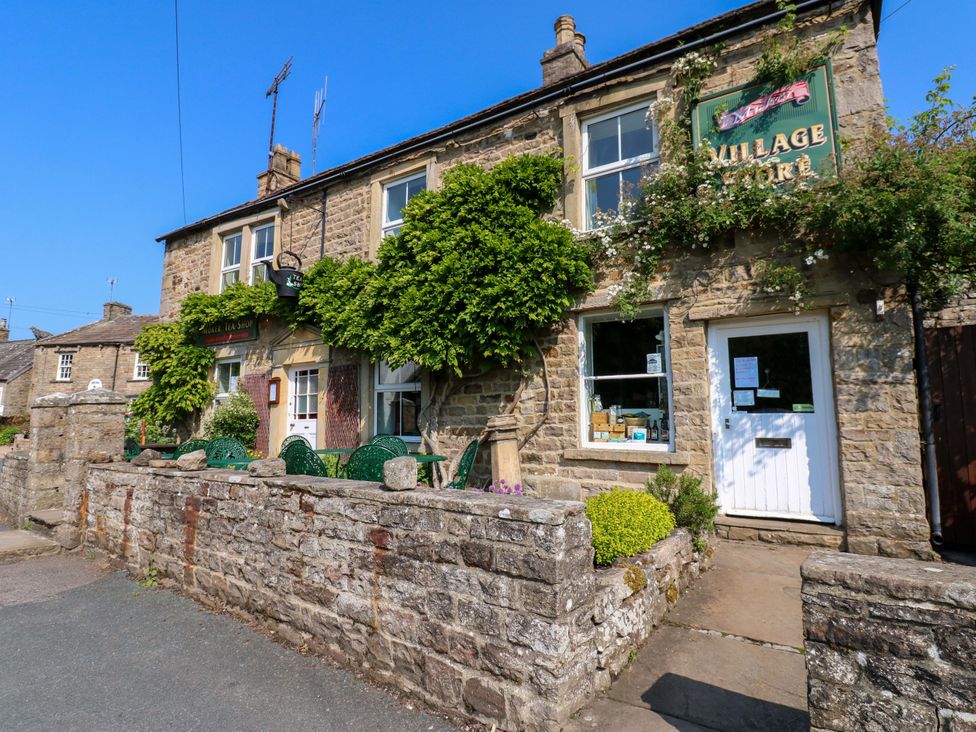 A stone building with a shop sign and plants at The Old Dairy in Richmond