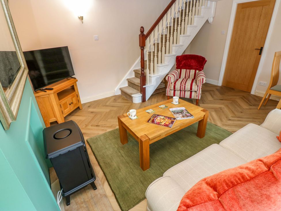 A living room with a sofa and television at The Old Dairy in Muker