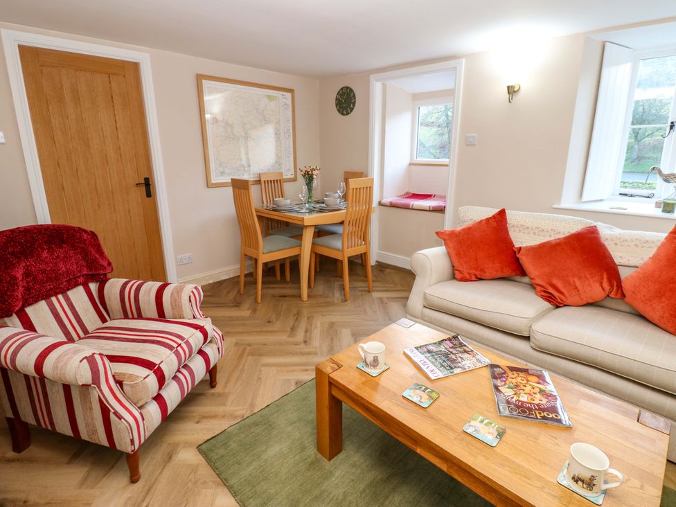 A living room with a sofa and dining area at The Old Dairy in Muker