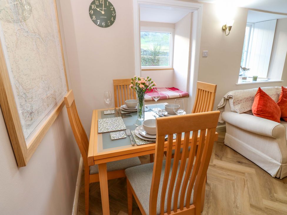A dining room with a table set for meals at The Old Dairy in Muker