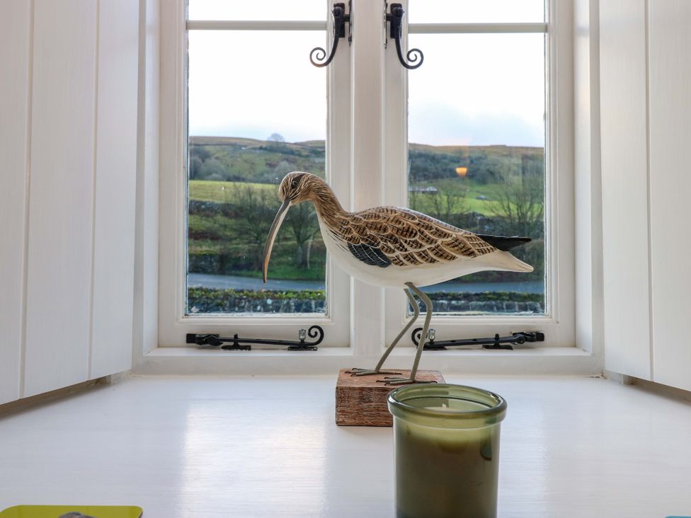 A bird sculpture on a table beside a candle at The Old Dairy in Muker