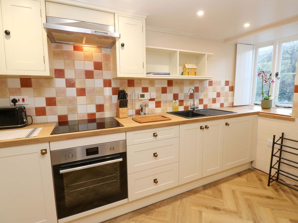 A kitchen with stove and sink at The Old Dairy in Muker