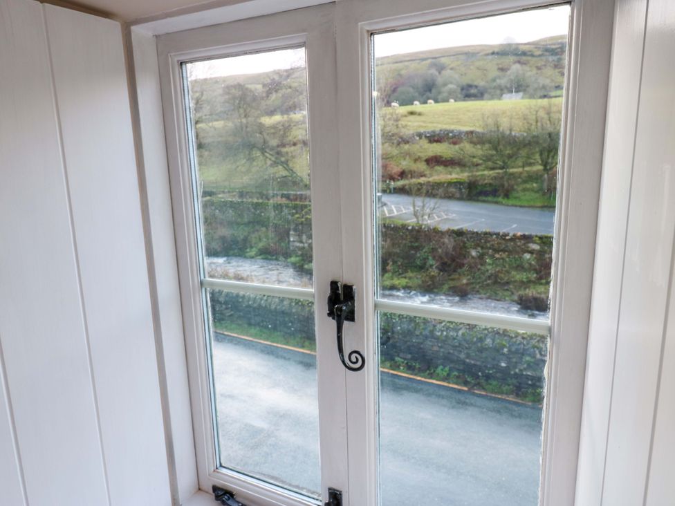 A window view of a road and landscape at The Old Dairy in Muker