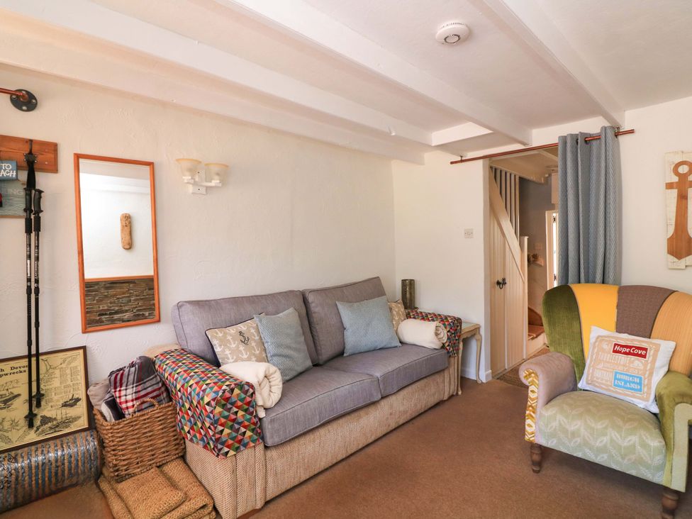 A living room with a sofa and an armchair at 2 The Square, Hope Cove