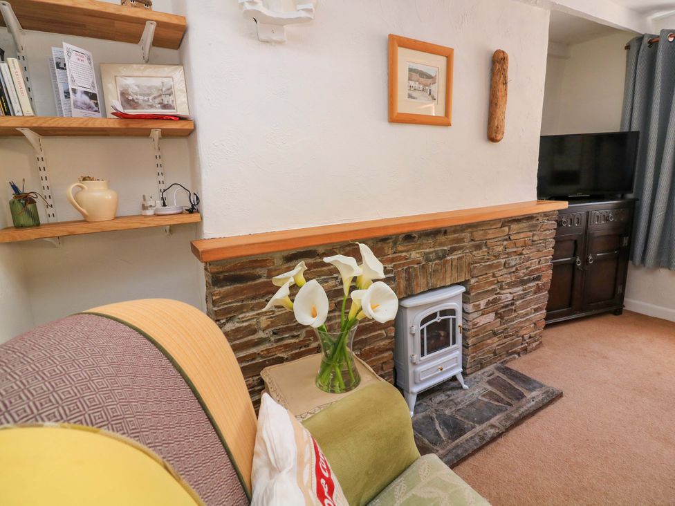 A living room with a gas stove and shelf at 2 The Square in Hope Cove