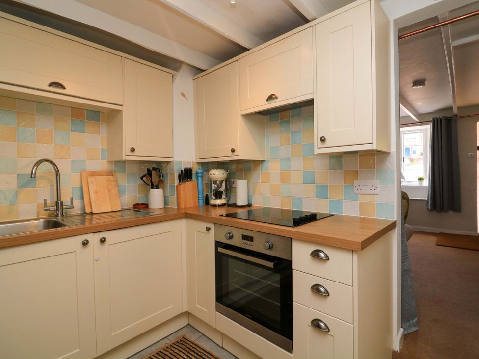 A kitchen with a sink and stove at 2 The Square in Hope Cove