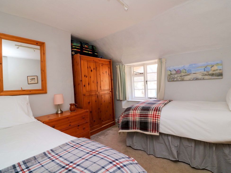 A bedroom with two beds and a wardrobe at 2 The Square Hope Cove
