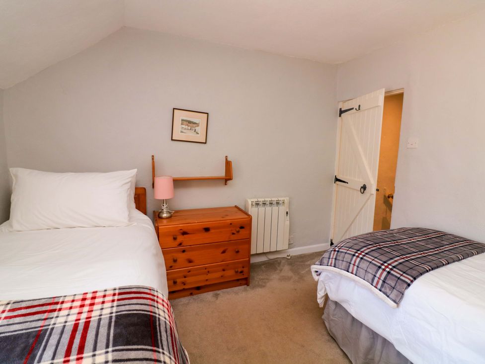 A bedroom with two beds and a dresser at 2 The Square Hope Cove