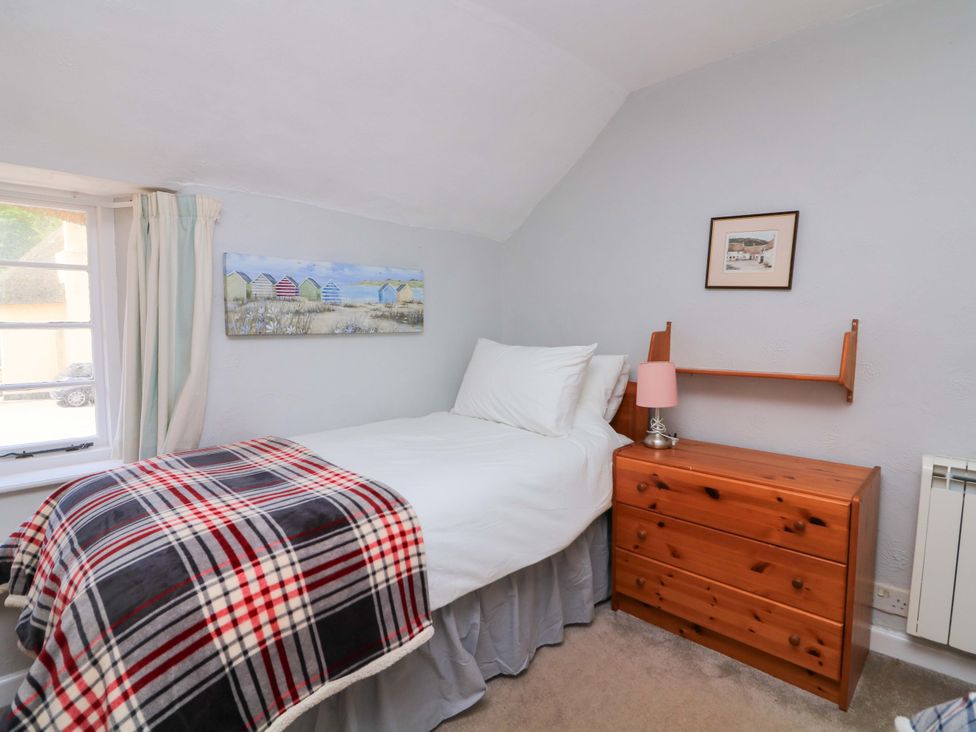 A bedroom with a single bed and dresser at 2 The Square Hope Cove