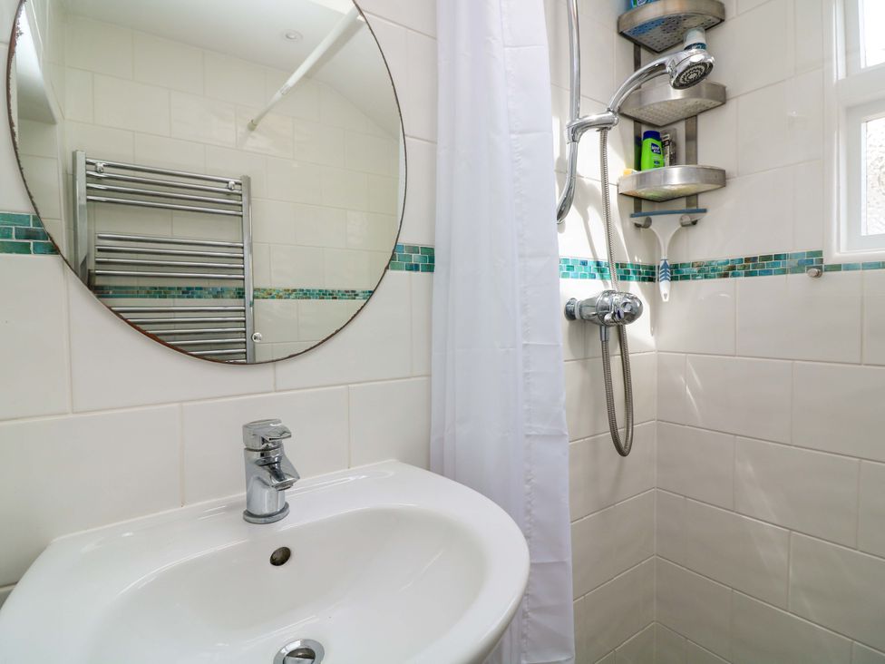 A bathroom with a sink and a shower at 2 The Square in Hope Cove