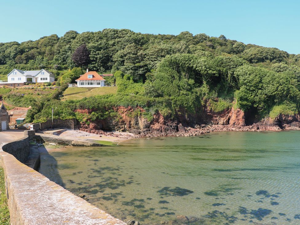 A view of houses on a cliff by the water at 2 The Square Hope Cove