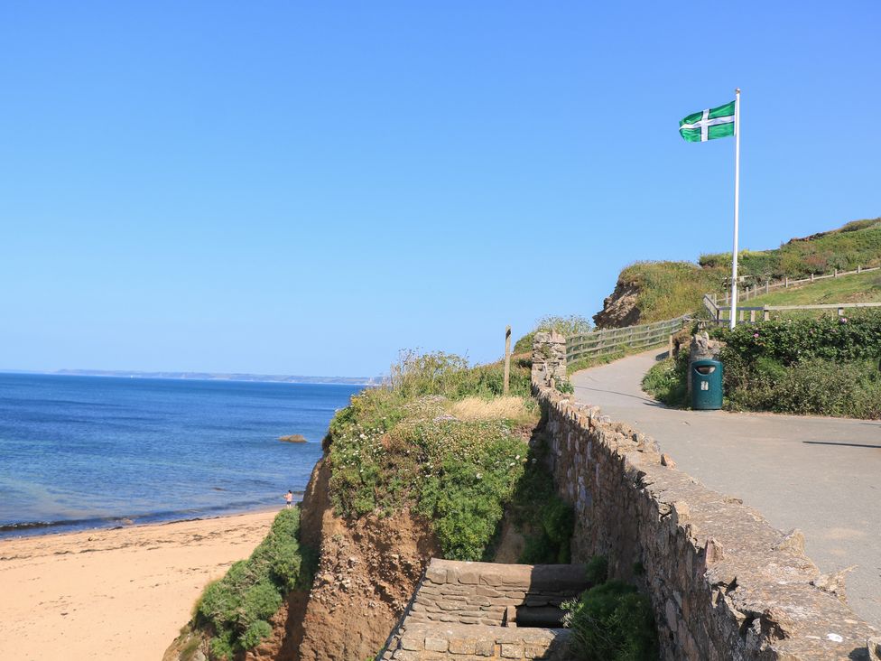 A coastal path with a flag and ocean view at 2 The Square in Hope Cove