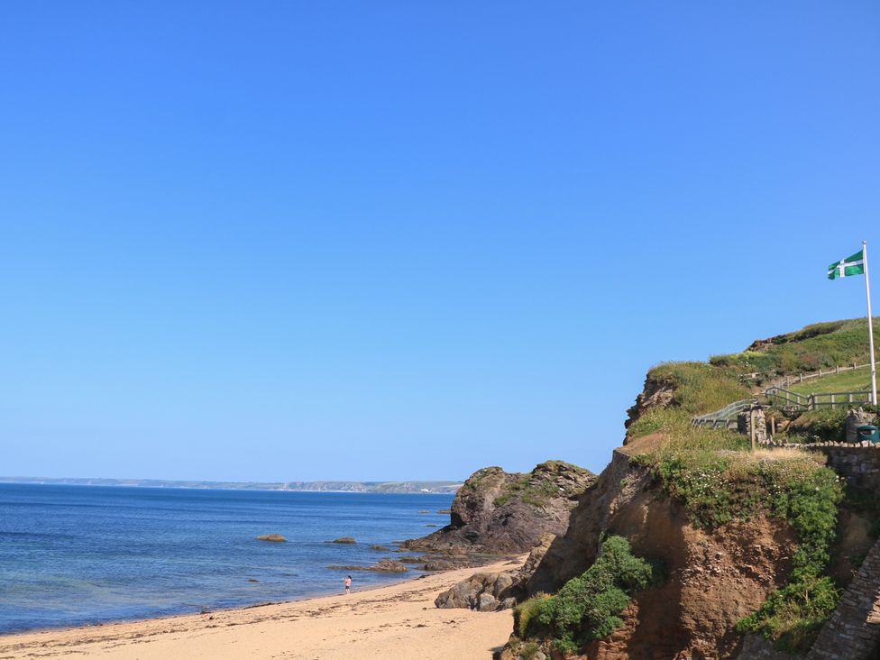 A beach scene with a cliff and ocean view at 2 The Square Hope Cove
