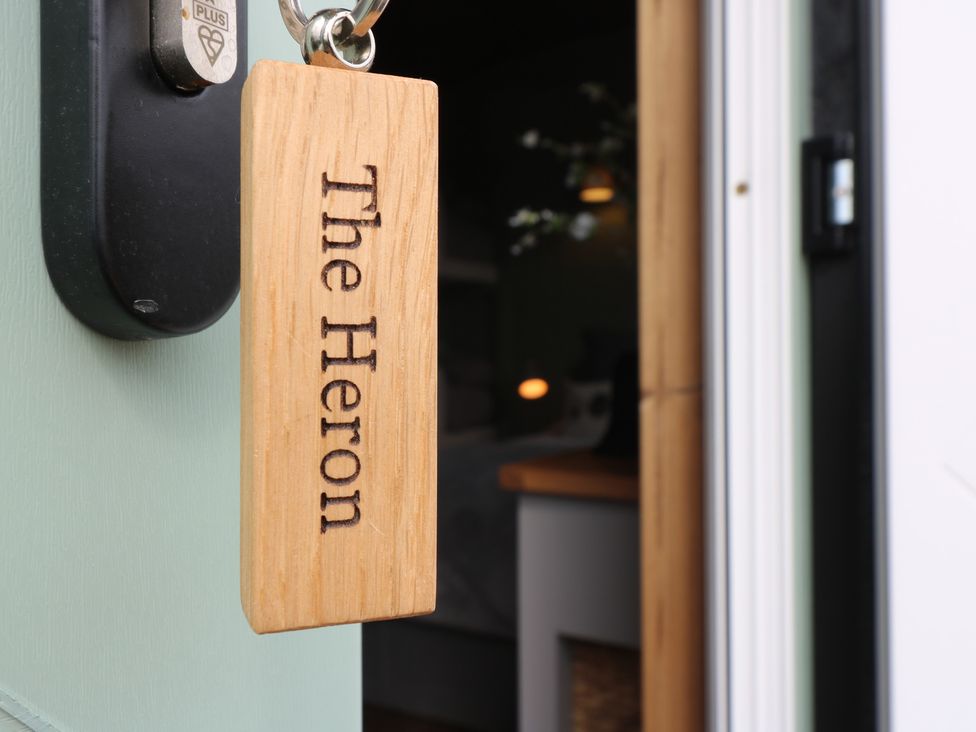 A wooden key tag with The Heron hanging on a door lock at The Heron in Lode near Bottisham