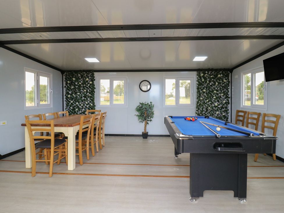 A game room with a billiards table and a wooden dining table with chairs at Barn Owl in Lode near Bottisham