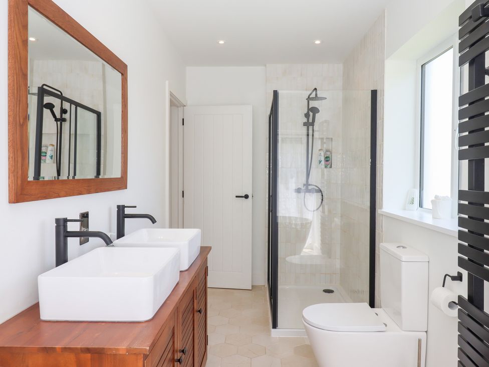 A bathroom with a shower and double wash basins at Clova in Brixham
