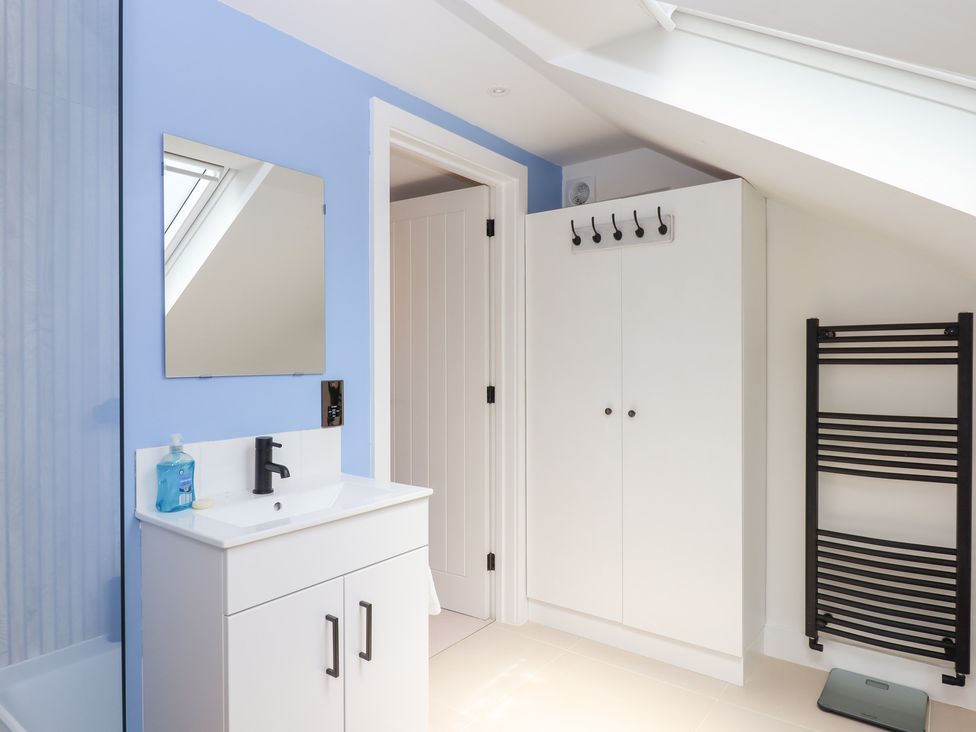 A bathroom with a wash basin and mirror at Clova in Brixham