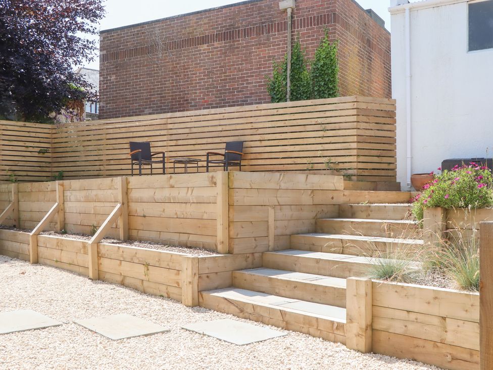 A garden with wooden decking and steps at Clova in Brixham