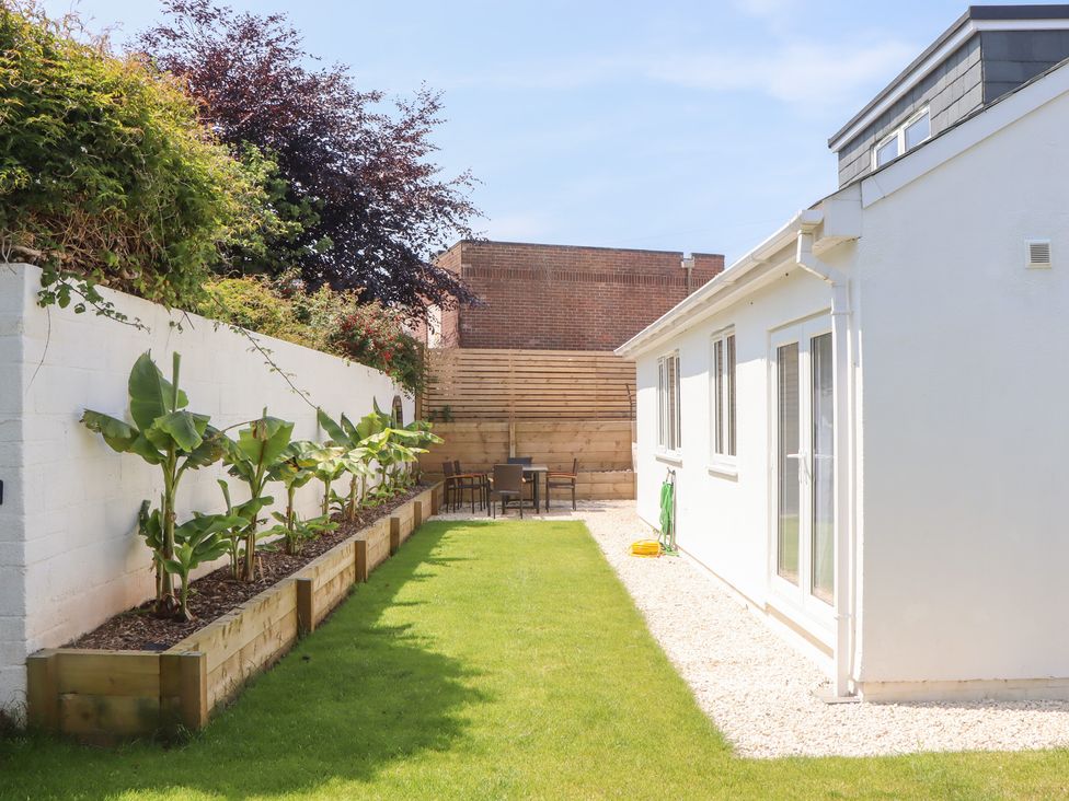 A garden with plants and seating area at Clova in Brixham