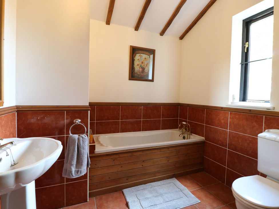 A bathroom with bathtub, sink, and toilet at Lakeside Barn Aylsham