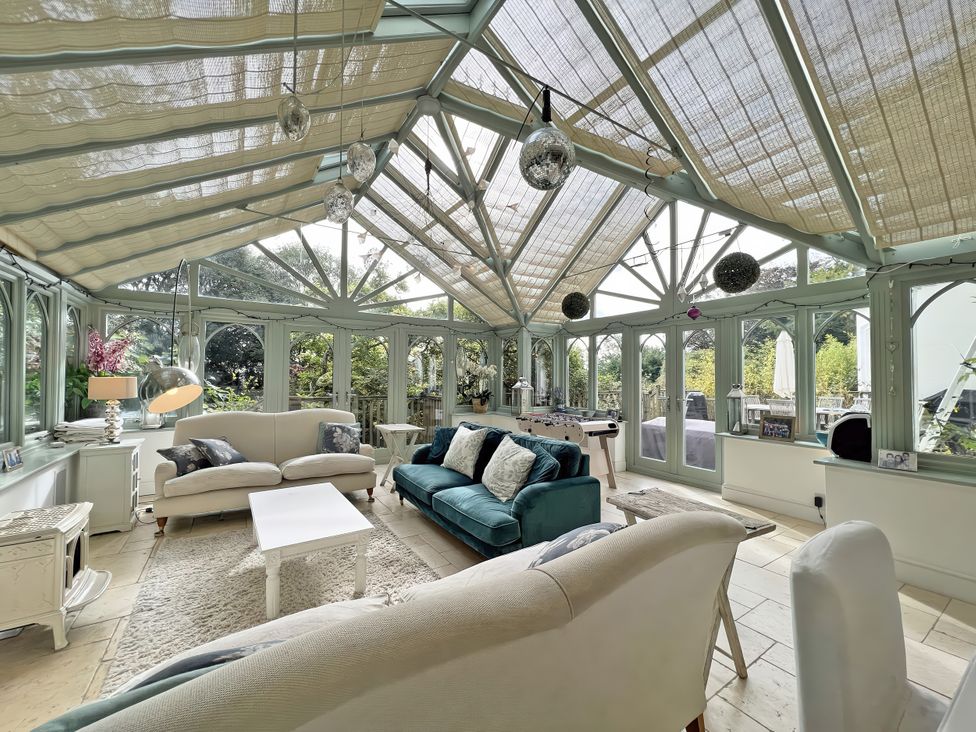 A conservatory with sofas and a coffee table at Trenare in Truro
