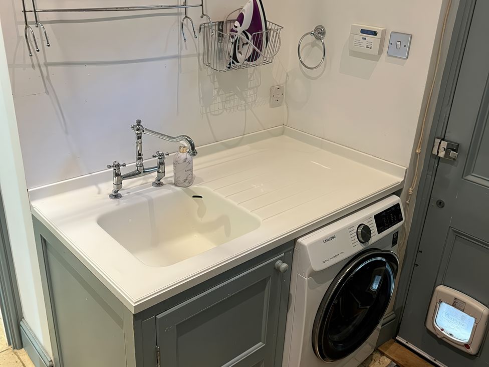 A laundry room with a sink and washing machine at Trenare in Truro