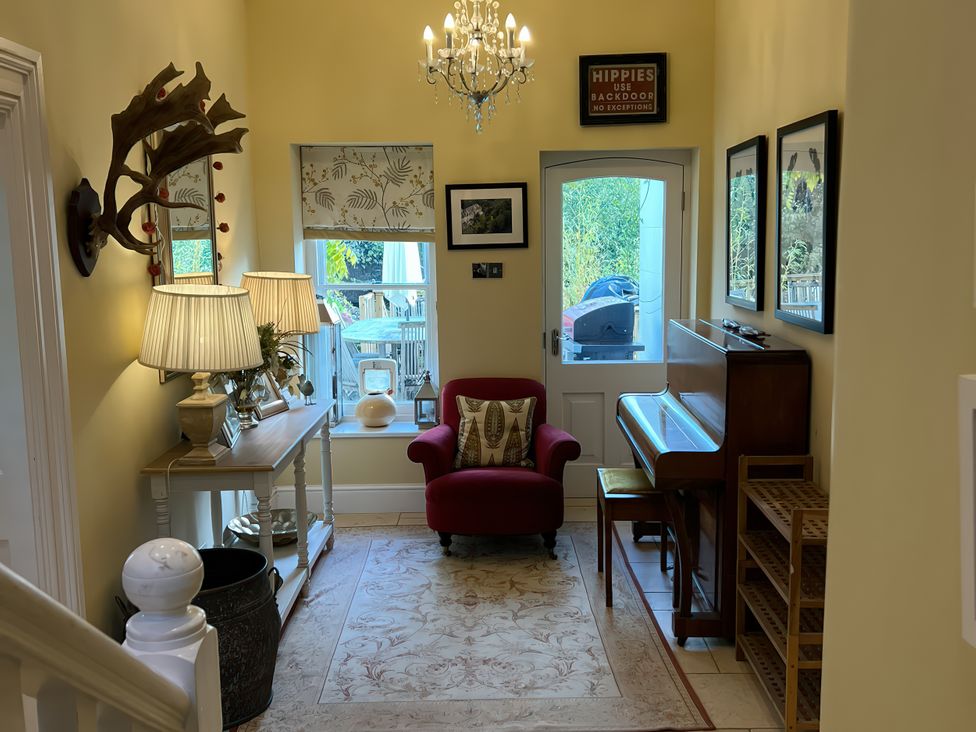 A hallway with a piano and chair at Trenare in Truro