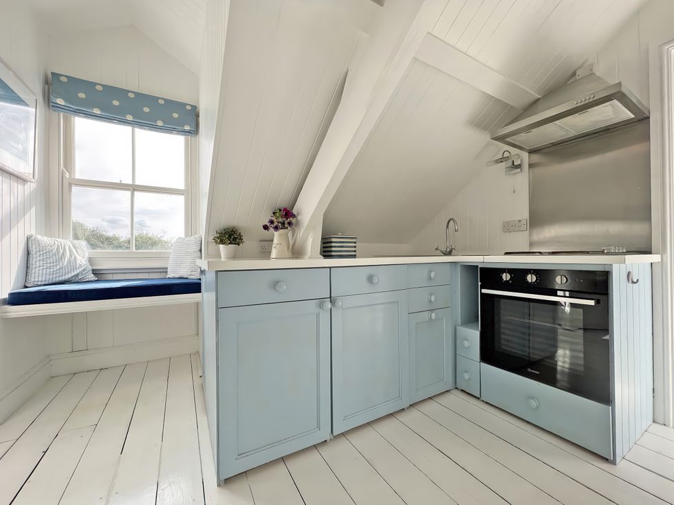 A kitchen with cabinets and a window at Trenare in Truro