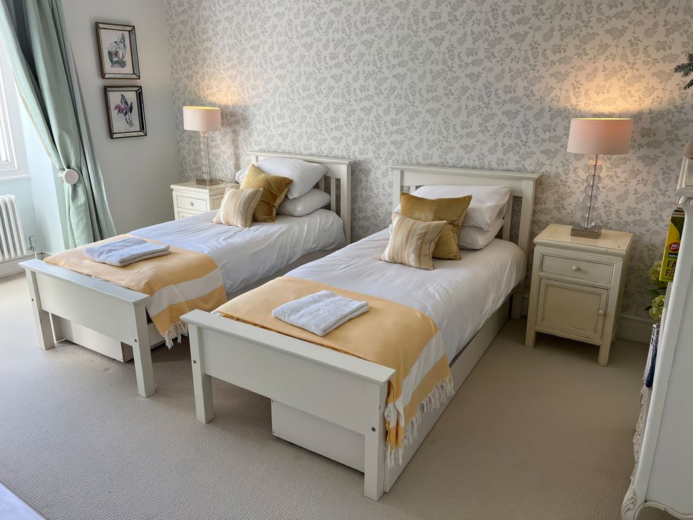 A bedroom with twin beds and lamps at Trenare in Truro