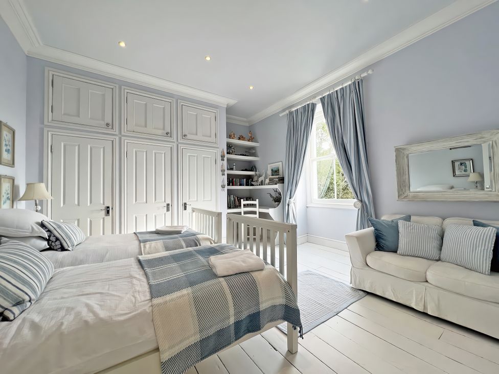 A bedroom with two beds and a crib at Trenare in Truro