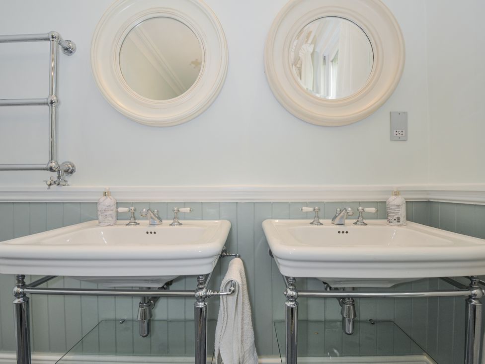 A bathroom with double sinks and mirrors at Trenare in Truro