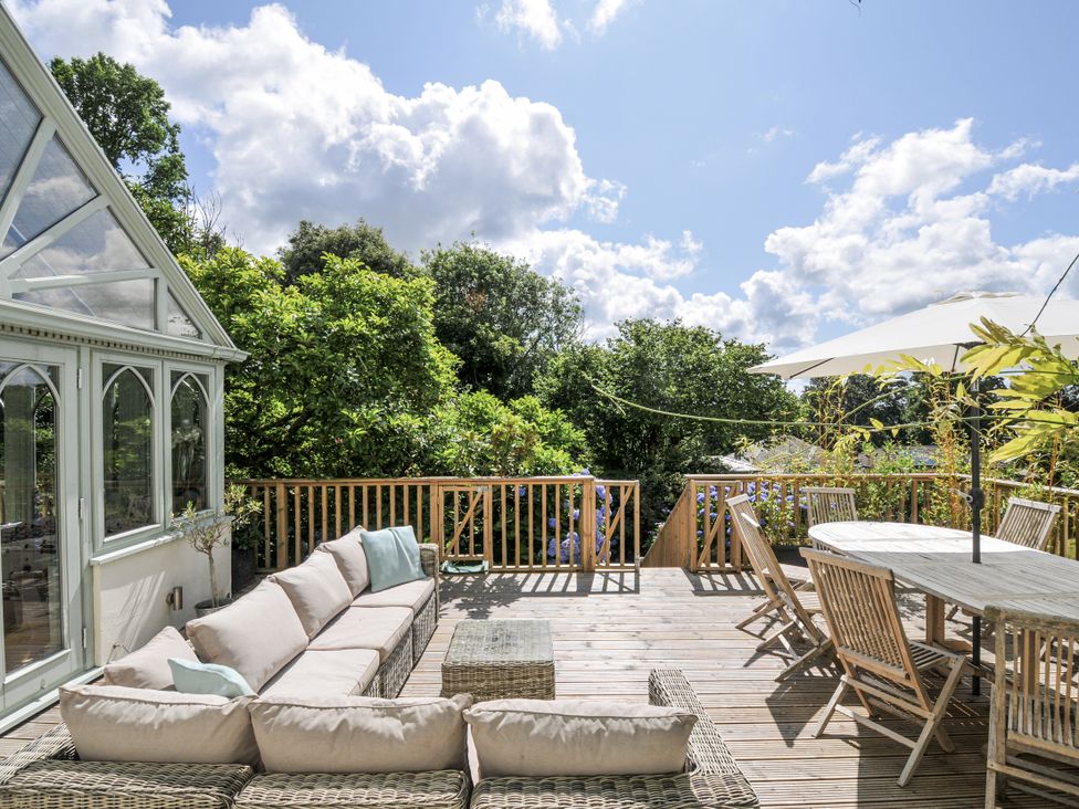 An outdoor seating area with a sofa and dining table at Trenare in Truro