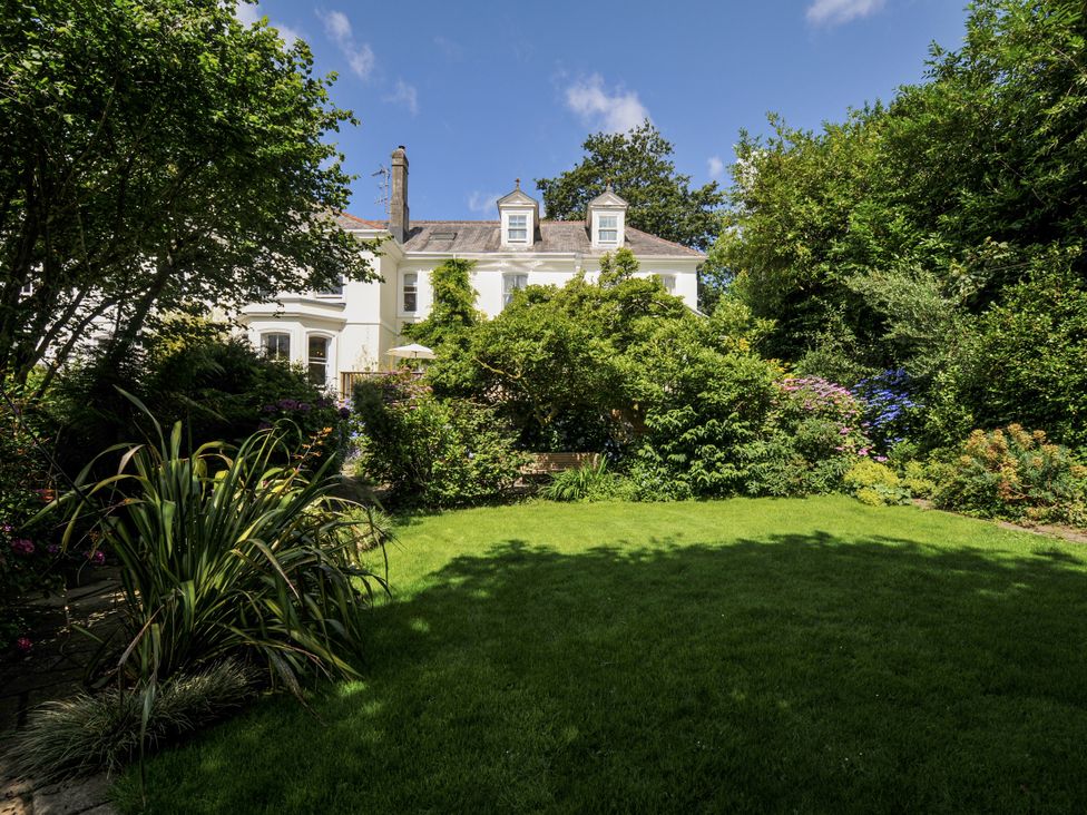 A garden with a house in the background at Trenare in Truro
