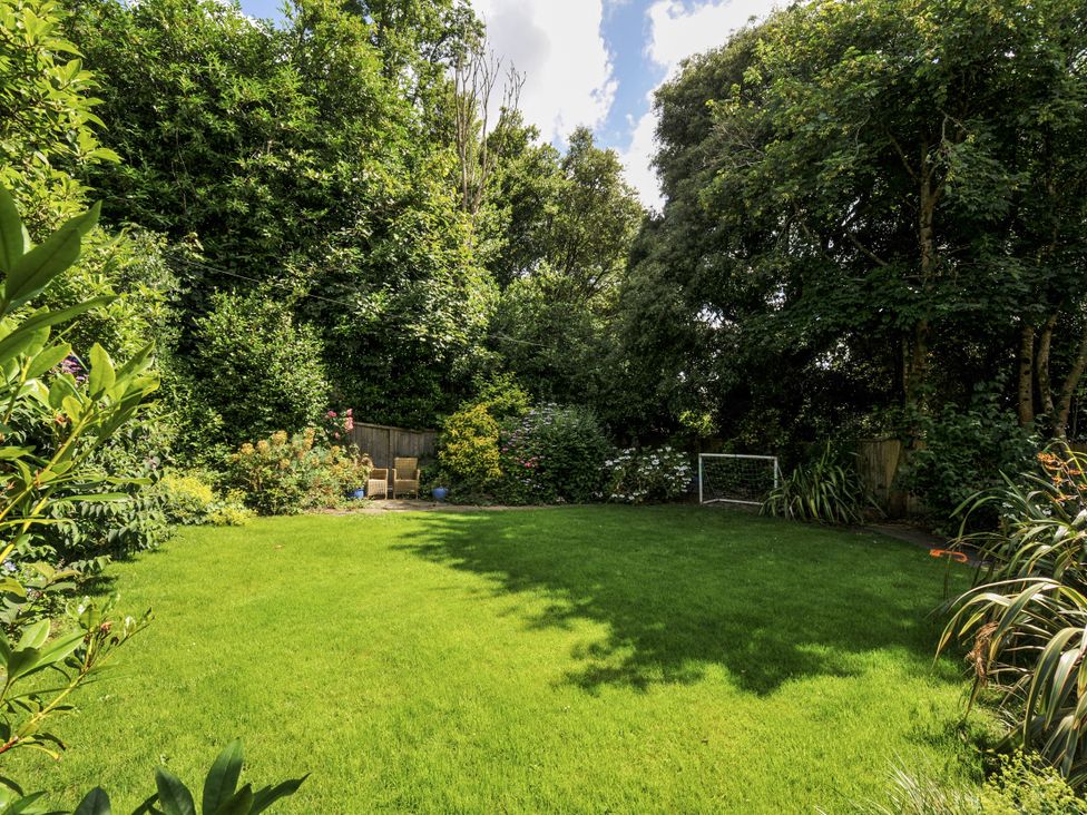 A garden with grass and trees at Trenare in Truro