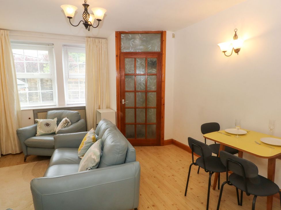 A living room with a sofa and dining table at Holme Cottage in Hebden Bridge