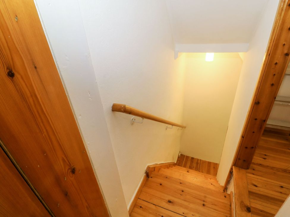A staircase with wooden floor and handrail at Holme Cottage in Hebden Bridge